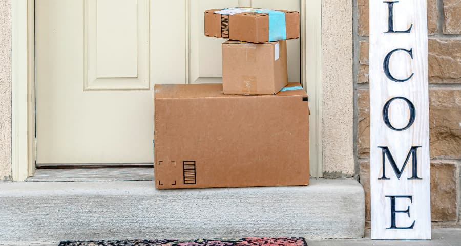 Boxes by the door of a residence with a welcome sign in Naperville